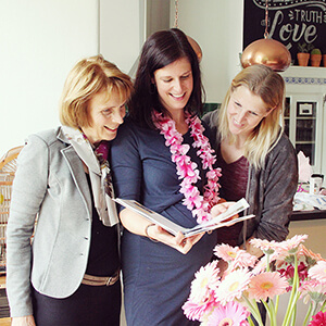 zwangere moeder ontvangt een vriendenboek van vriendinnen als cadeau op haar babyshower